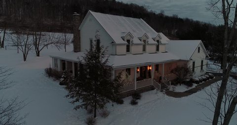 A slow aerial zoom into the porch of a Pennsylvanian farmhouse decorated for Christmas at night. Pittsburgh suburbs.	 	