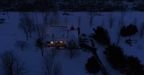 A high angle night aerial perspective of a farmhouse decorated for Christmas in the Pennsylvania countryside. Pittsburgh suburbs.  	