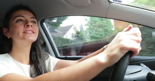Woman driving car. Candid authentic real life 4K clip of young woman holding steering wheel and traveling somewhere