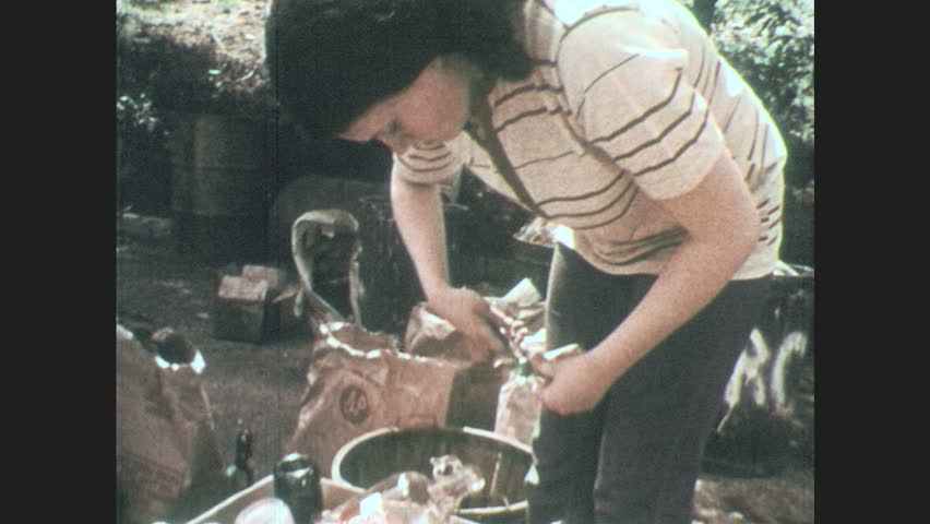 1970s: Woman sorts glass bottles. Woman uses pliers. | Shutterstock HD Video #1007320564