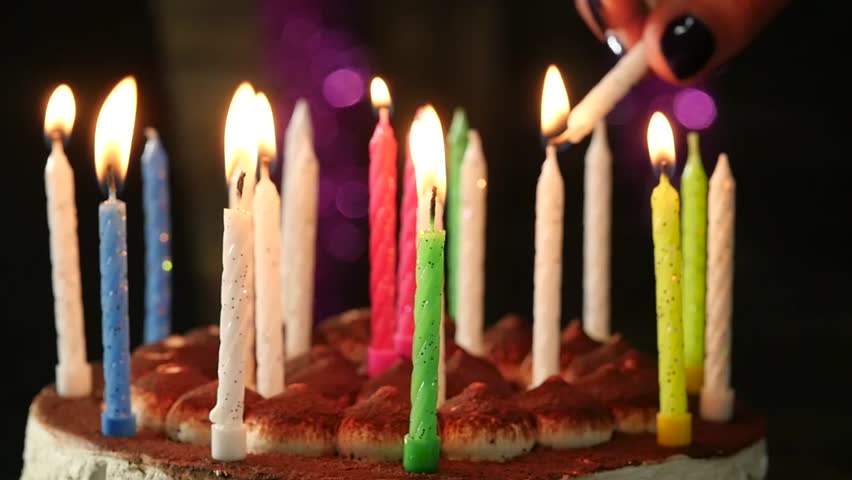 Woman lights candles on tasty birthday cake. Slow motion Royalty-Free Stock Footage #1007333650