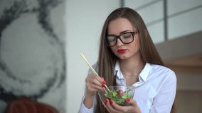 4k video of elegant businesswoman having lunch on her working place. Woman eating vegetable salad in office. 4 k