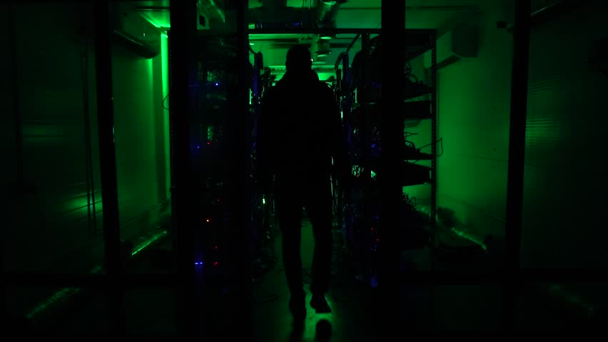 The dark silhouette goes into the distance on a green background. There are a lot of computers. Strange scientist. Programmer.mining farm