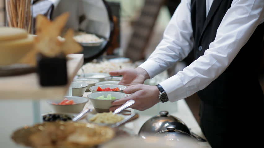 The buffet in the restaurant. The waiter serves the table | Shutterstock HD Video #1007345806
