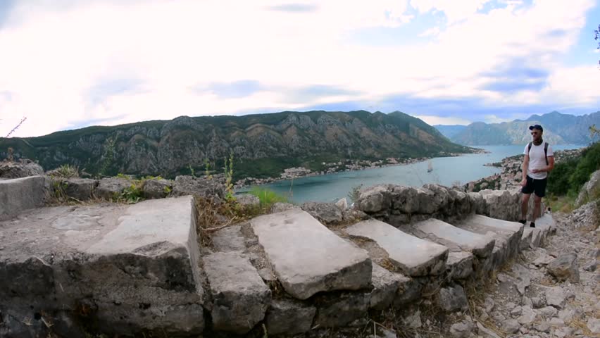 A man in the mountains climbing a stone staircase to Kotor
