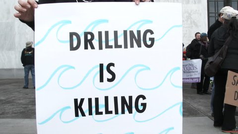 SALEM, OREGON - FEBRUARY 2018: Person holding sign reading "Drilling is Killing" at protest for offshore drilling.
