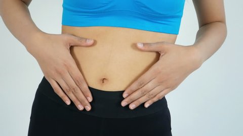 Close up of Woman touching her stomach while wearing a fitness suit