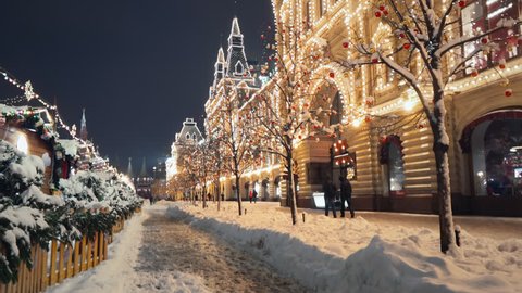 Beautiful Red Square New Year winter decorations, steady camera shot along night shining pedestrian street in the center of Moscow, trees with bright lights and balls are covered with snow., videoclip de stoc