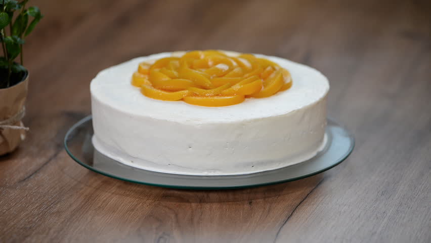 Chef decorating a delicious peach cake with cream