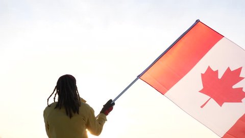 A man is standing with his back to the flag of Canada. support team. Stockvideó
