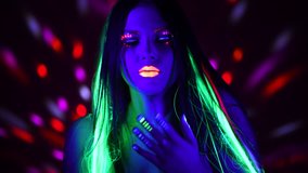 Disco dancer girl in neon light, beautiful model woman with fluorescent make-up, Art design of female disco dancer dancing in UV light, colorful make up. Night club, Party. 4K UHD video footage