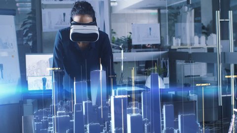 Professional Female Architect Wearing Makes Gestures with Augmented Reality Headset, Shows Statistics for 3D City Model. High Tech Office Use Virtual Reality Modeling Software Application.