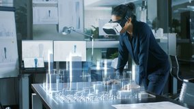 Professional Female Architect Wearing Makes Gestures with Augmented Reality Headset, Shows Statistics for 3D City Model. High Tech Office Use Virtual Reality Modeling Software Application. - Powered by Shutterstock - Get 15% off with code: PIKWIZARD15