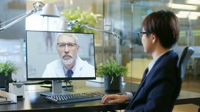 In the Office Businessman Talks with His Doctor On the Video Call Made with Personal Computer. Senior Physician Consults and Writes Perescription to East Asian Businessman. Shot on RED EPIC-W 8K 