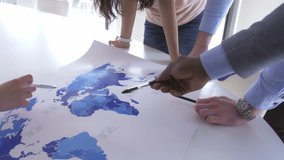 Business team focusing on the world map in a modern office. Young workers collaborating to find out future opportunities for better economic results. - Powered by Shutterstock - Get 15% off with code: PIKWIZARD15