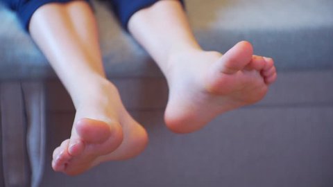 children's legs without socks carefree lying on the couch