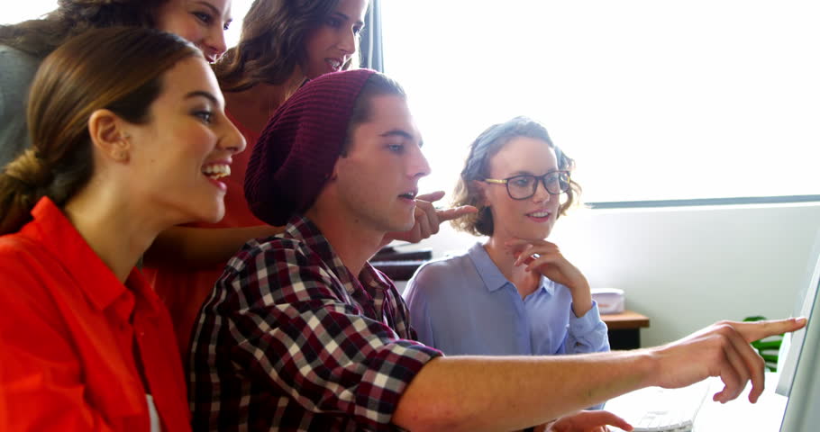 Business executives working on computer at desk in office