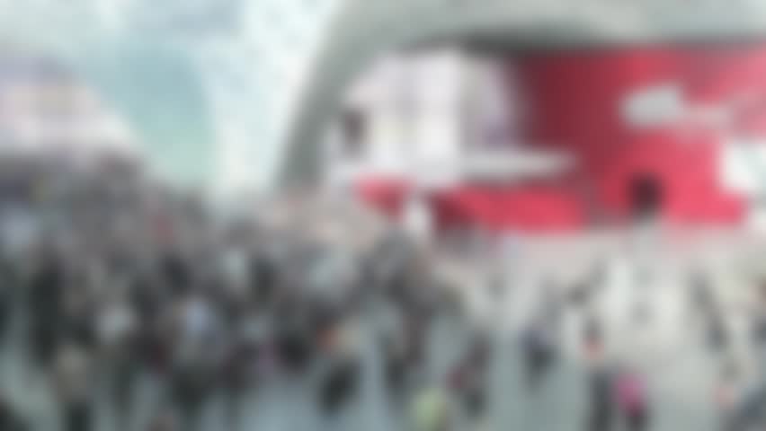 People crowd at the entrance of trade show. Background with an intentional blur effect applied. Location unrecognizable.