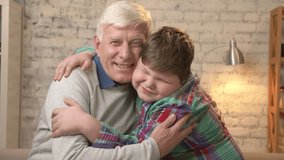 Grandfather and grandson embrace. Young fat boy and elderly grandfather. Happy family concept. 60 fps