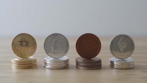 Camera tilting down to four piles of crypto currency coins 
