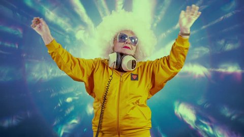 Time lapse of DJ grandma with white afro hair, sunglasses and headphones raving in club