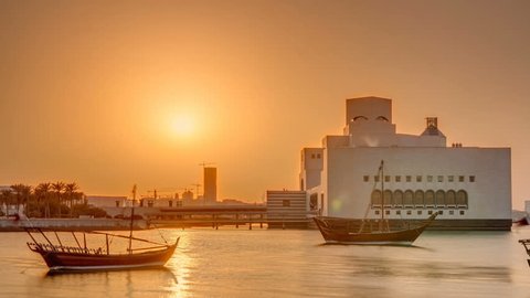 Sunset near Museum of Islamic Art in Doha timelapse, Qatar, view with the emerging high-rise skyline behind it. Old boats on foreground.