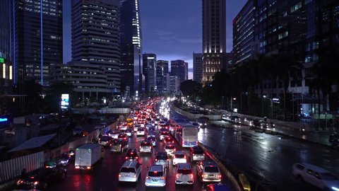 Time lapse of a traffic jam along the Sudirman avenue in the heart of Jakarta business district at night in Indonesia capital city. Construction works is for the new MRT station.
