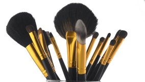 Make-up Brushes set rotated over white background. Professional makeup brush rotation on white in studio. Make up artist tools. 4K UHD video