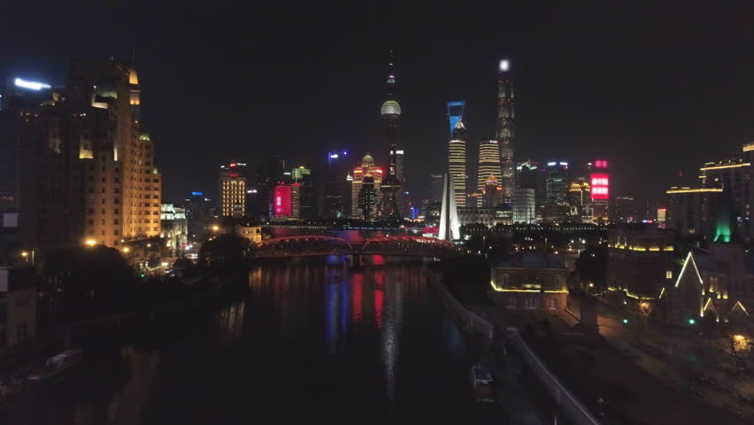 Illuminated Shanghai Skyline at Night. Lujiazui District, Huangpu River and Suzhou Creek. China. Aerial View. Drone is Flying Forward and Upward. Establishing Shot.
 Royalty-Free Stock Footage #1007444812