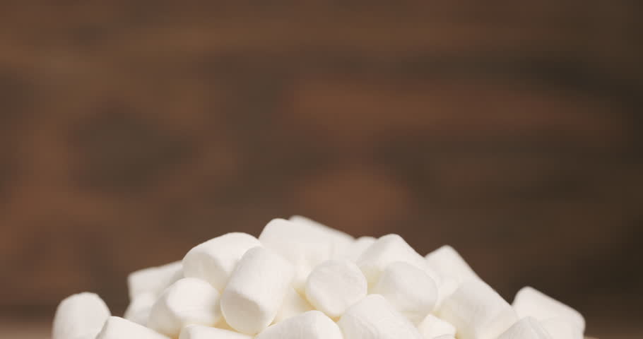 white marshmallows in wooden bowl on table