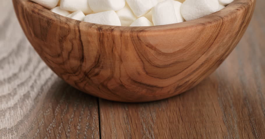 white marshmallows in wooden bowl on table