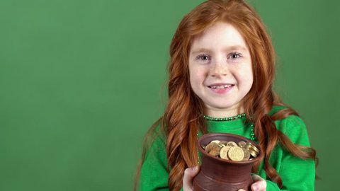 Girl red hair celebrating saint patrick's day green wall background looking on pot with gold