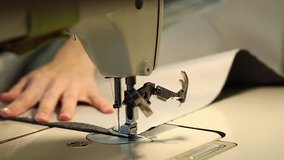 Woman working at a sewing machine,  needle sewing machine, female hands, Slow Motion Video, close-up, shallow depth of field