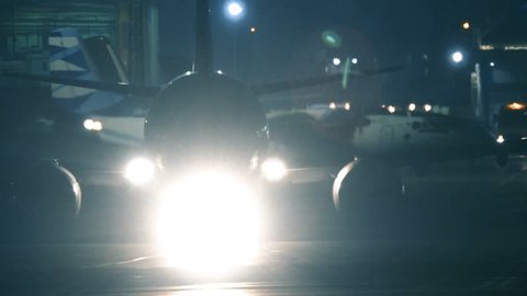 Airplane maneuvers on a runway at night before take off