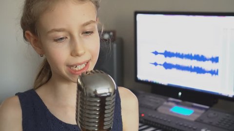 Little girl singing a song in home recording studio.