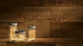 This is a video of fireflies or lightning bugs dancing inside glass jars on an old wood retro background. This video would work well for summertime capturing the magic of the old fashioned country.