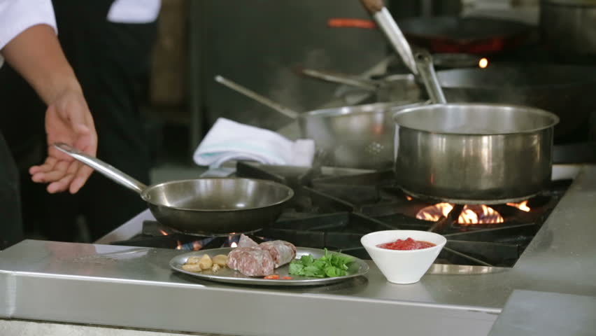 Preparing sausages in the frying pan, restaurant kitchen, proffesional cooking