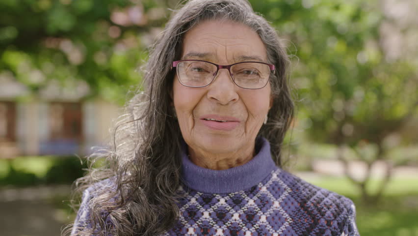 portrait of pretty elderly indian woman smiling happy looking at camera in garden background wearing glasses Royalty-Free Stock Footage #1007522257
