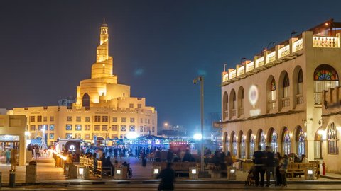 Souq Waqif night timelapse. It is popular marketplace in Doha, Qatar. The souq is noted for selling traditional garments, spices, handicrafts, and souvenirs. Islamic center on background