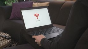 Over the shoulder view of a man sitting in a couch with his laptop that connects to wifi. - Powered by Shutterstock - Get 15% off with code: PIKWIZARD15