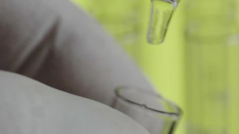 Close up of laboratory scientist hand  working with a pipette analyzes and extract the DNA or molecules in the test tubes.on lime background
