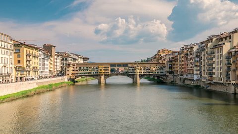 The Ponte Vecchio, famous medieval stone bridge over the Arno river in Florence, Italy. Camera zoom out.