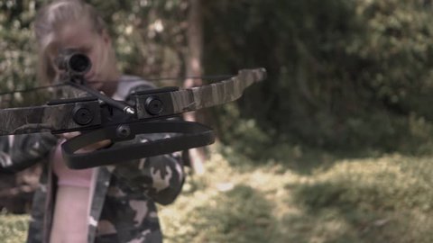 2 in 1 video. blonde in camo jacket is shooting from a crossbow camera rotating