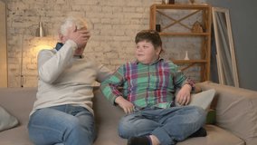Grandson gives his Grandfather a gift. a fat child gives a gift to An elderly man, Joy, surprise, happiness, emotion, feeling, impulsively, present, hug. Home comfort, family idyll, cosiness concept