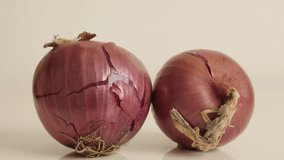 Tilting over onion with red skin and white flesh close-up 4K 2160p 30fps UltraHD footage - Organic vegetable Allium cepa slow tilt 3840X2160 UHD video