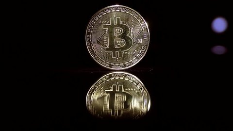Video in 4k resolution bitcoin coin on a black background. Playing with light.