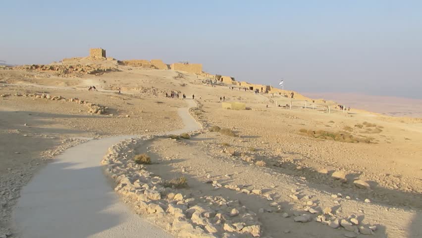 Masada, Israel, December 30, 2017:  Some people walk among the ancient remains of a walls of the palace of Herod at Masada, an ancient fortress in the south-west coast of the Dead Sea in Israel.