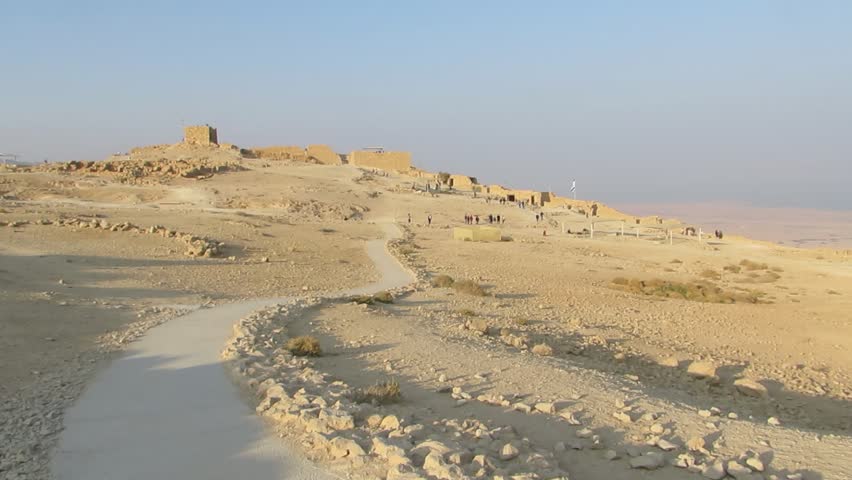 Masada, Israel, December 30, 2017:  Some people walk among the ancient remains of a walls of the palace of Herod at Masada, an ancient fortress in the south-west coast of the Dead Sea in Israel.