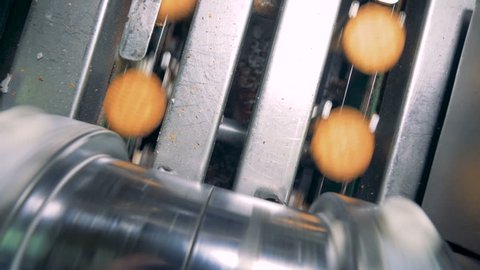 Top view of filling being put down on cookies by a factory machine