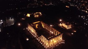 Aerial drone night video of iconic ancient Acropolis hill and the Parthenon at night, Athens historic center, Attica, Greece